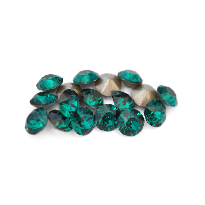 Round faceted Austrian crystal rhinestones in the color Emerald displayed on a white background