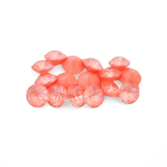 Round faceted Austrian crystal rhinestones in the color Flamingo Ignite displayed on a white background