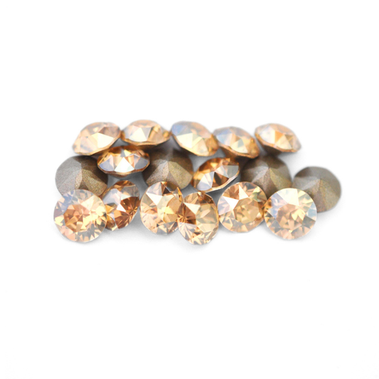 Round faceted Austrian crystal rhinestones in the color Golden Shadow displayed on a white background