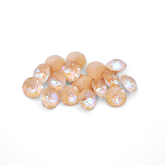 Round faceted Austrian crystal rhinestones in the color Ivory Cream Delite displayed on a white background