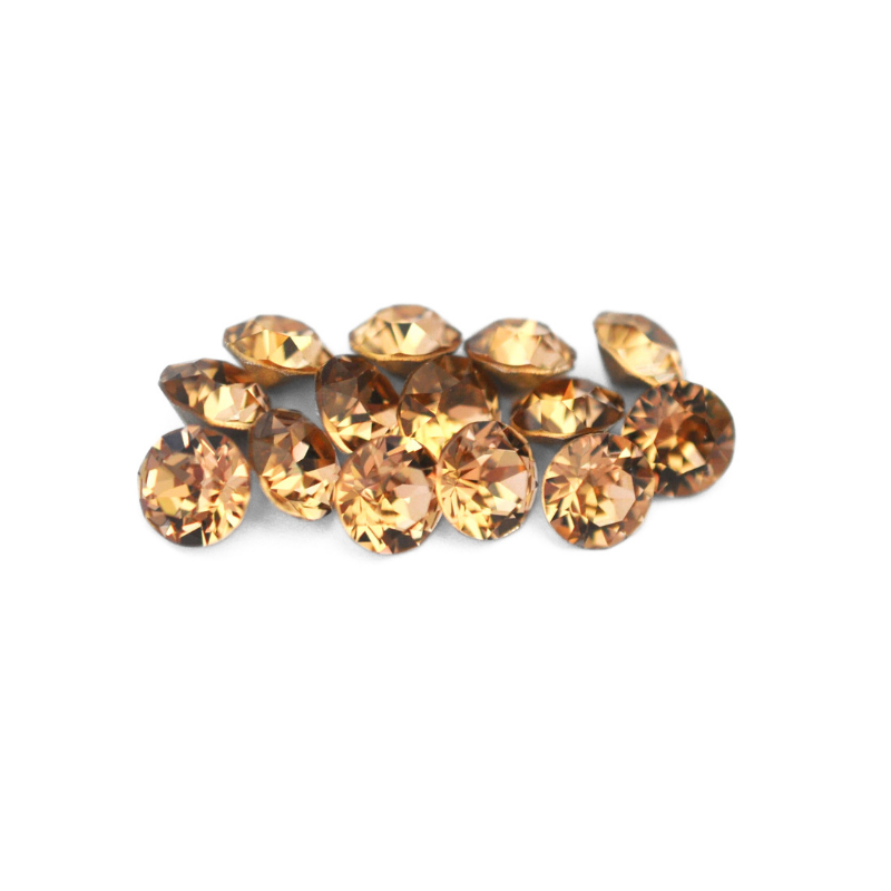 Round faceted Austrian crystal rhinestones in the color Light Colorado Topaz displayed on a white background