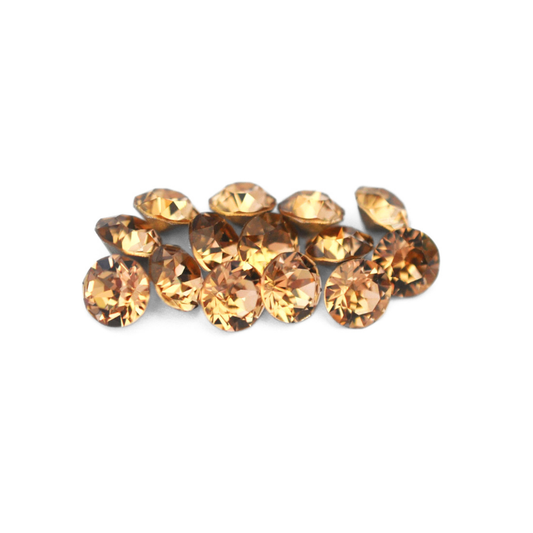 Round faceted Austrian crystal rhinestones in the color Light Colorado Topaz displayed on a white background