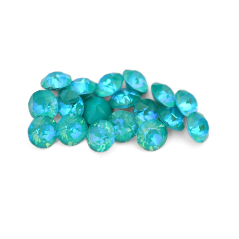 Round faceted Austrian crystal rhinestones in the color Laguna Delite displayed on a white background
