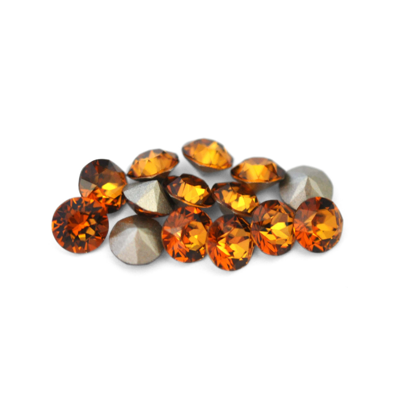 Round faceted Austrian crystal rhinestones in the color Light Amber displayed on a white background