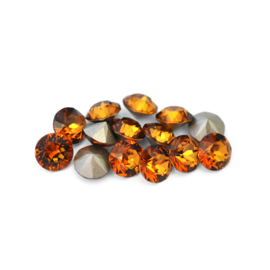 Round faceted Austrian crystal rhinestones in the color Light Amber displayed on a white background