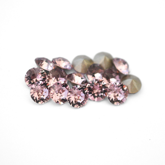 Round faceted Austrian crystal rhinestones in the color Light Amethyst displayed on a white background