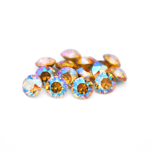 Round faceted Austrian crystal rhinestones in the color Light Topaz Shimmer displayed on a white background