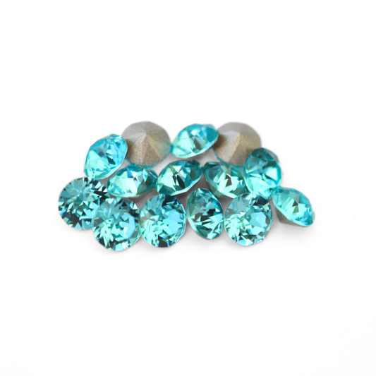 Round faceted Austrian crystal rhinestones in the color Light Turquoise displayed on a white background