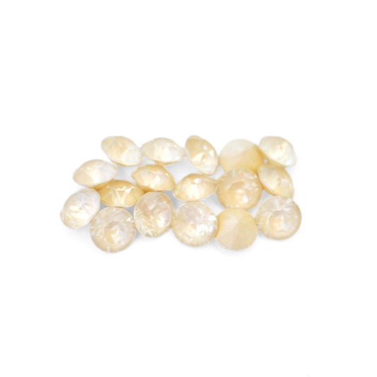 Round faceted Austrian crystal rhinestones in the color Linen Ignite displayed on a white background