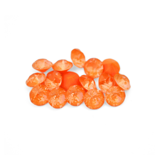Round faceted Austrian crystal rhinestones in the color Mango Ignite displayed on a white background