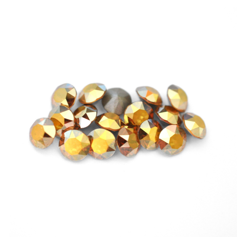 Round faceted Austrian crystal rhinestones in the color Metallic Sunshine displayed on a white background