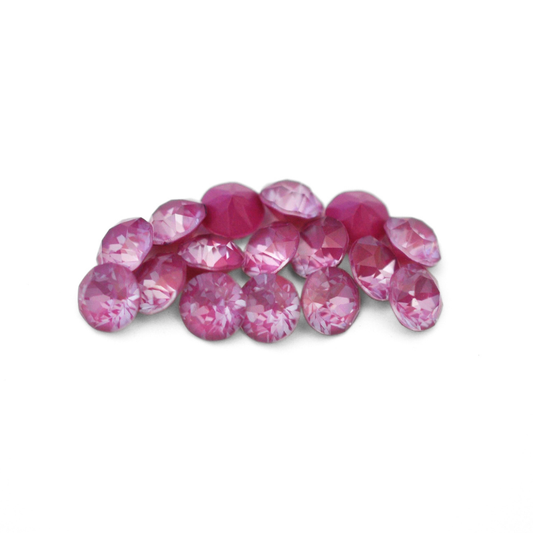 Round faceted Austrian crystal rhinestones in the color Orchid Ignite displayed on a white background