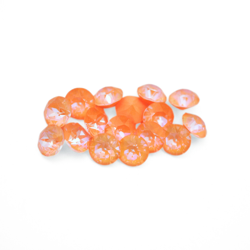 Round faceted Austrian crystal rhinestones in the color Peach Delite displayed on a white background