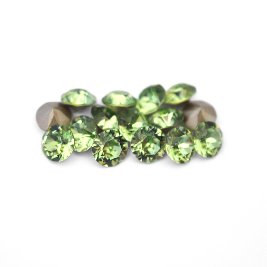 Round faceted Austrian crystal rhinestones in the color Peridot displayed on a white background