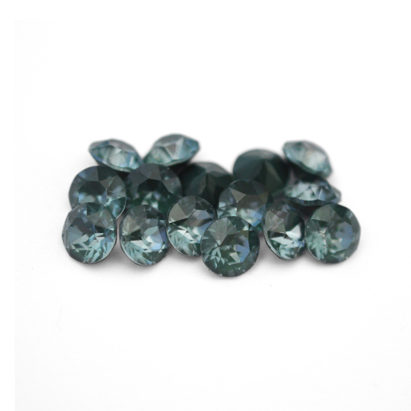 Round faceted Austrian crystal rhinestones in the color Pine Green Ignite displayed on a white background