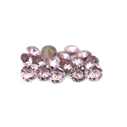 Round faceted Austrian crystal rhinestones in the color Rosaline displayed on a white background