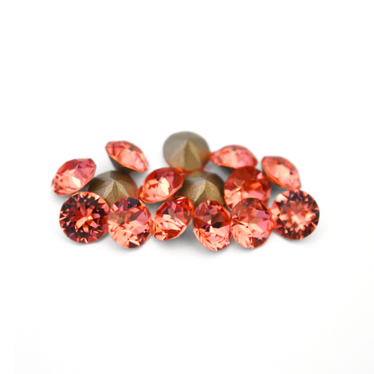 Round faceted Austrian crystal rhinestones in the color Rose Peach displayed on a white background