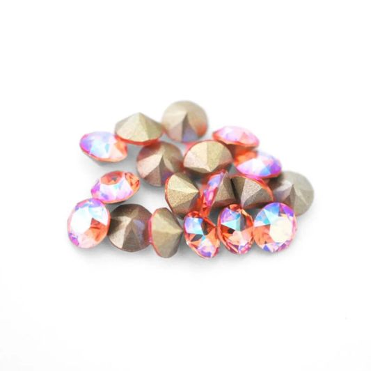 Round faceted Austrian crystal rhinestones in the color Rose Peach Shimmer displayed on a white background