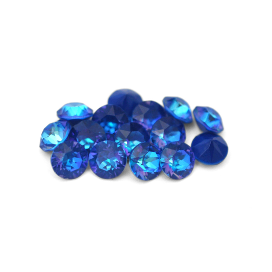 Round faceted Austrian crystal rhinestones in the color Royal Blue Delite displayed on a white background