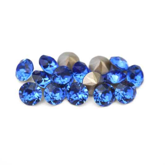 Round faceted Austrian crystal rhinestones in the color Sapphire displayed on a white background