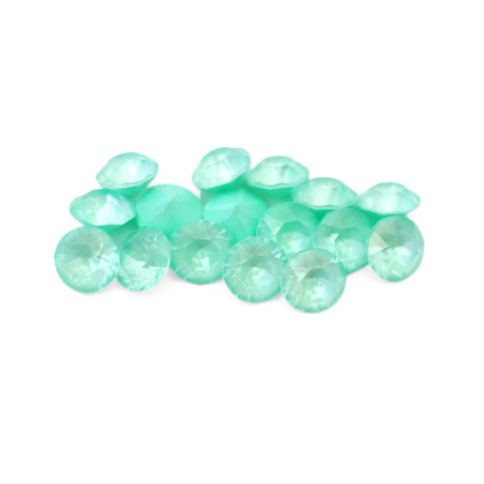 Round faceted Austrian crystal rhinestones in the color Soft Mint Ignite displayed on a white background