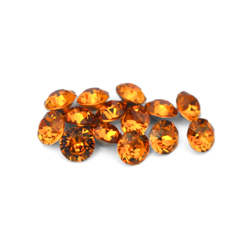 Round faceted Austrian crystal rhinestones in the color Topaz displayed on a white background