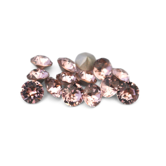Round faceted Austrian crystal rhinestones in the color Vintage Rose displayed on a white background