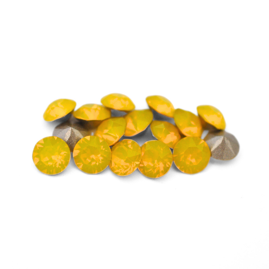 Round faceted Austrian crystal rhinestones in the color Yellow Opal displayed on a white background
