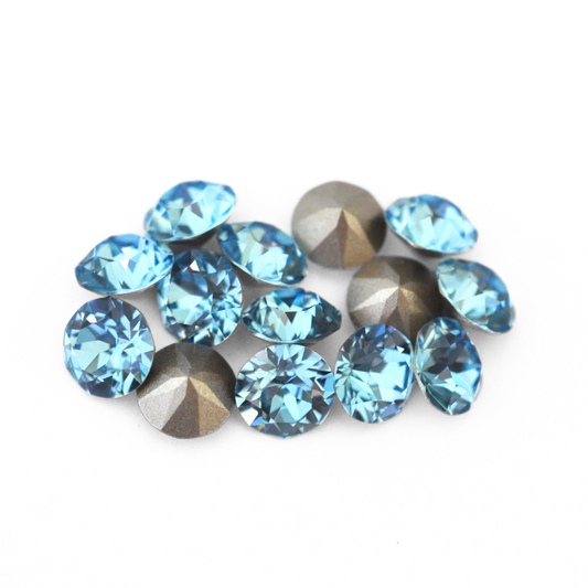 Round faceted Austrian crystal rhinestones in the color Aquamarine displayed on a white background