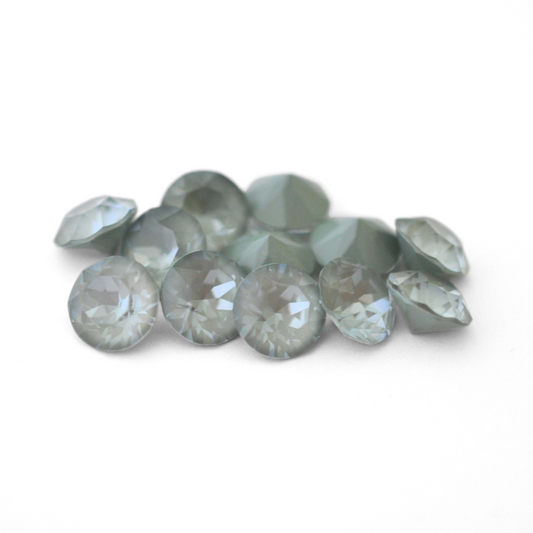 Round faceted Austrian crystal rhinestones in the color Agave Ignite displayed on a white background.
