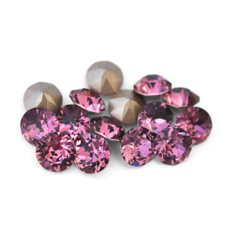 Round faceted Austrian crystal rhinestones in the color Antique Pink displayed on a white background.
