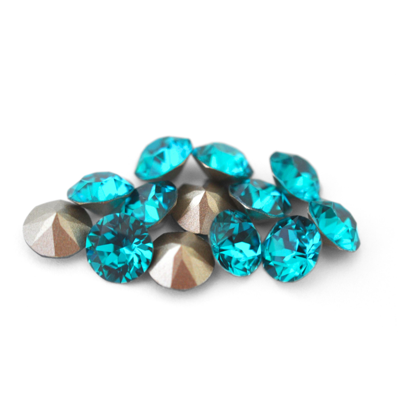 Round faceted Austrian crystal rhinestones in the color Blue Zircon displayed on a white background.