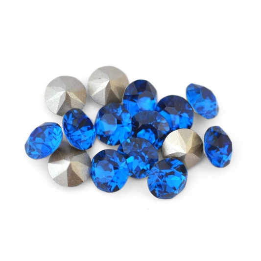 Round faceted Austrian crystal rhinestones in the color Capri Blue displayed on a white background