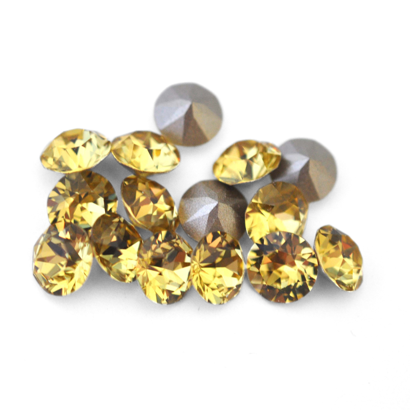 Round faceted Austrian crystal rhinestones in the color Dark Jonquil displayed on a white background.