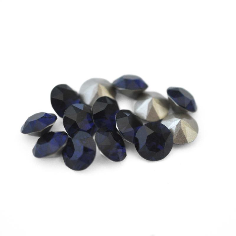 Round faceted Austrian crystal rhinestones in the color Dark Indigo displayed on a white background.