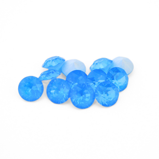 Round faceted Austrian crystal rhinestones in the color Electric Blue Ignite displayed on a white background.