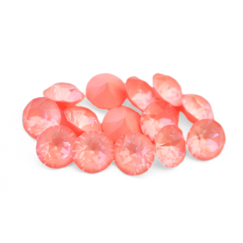 Round faceted Austrian crystal rhinestones in the color Flamingo Ignite displayed on a white background.