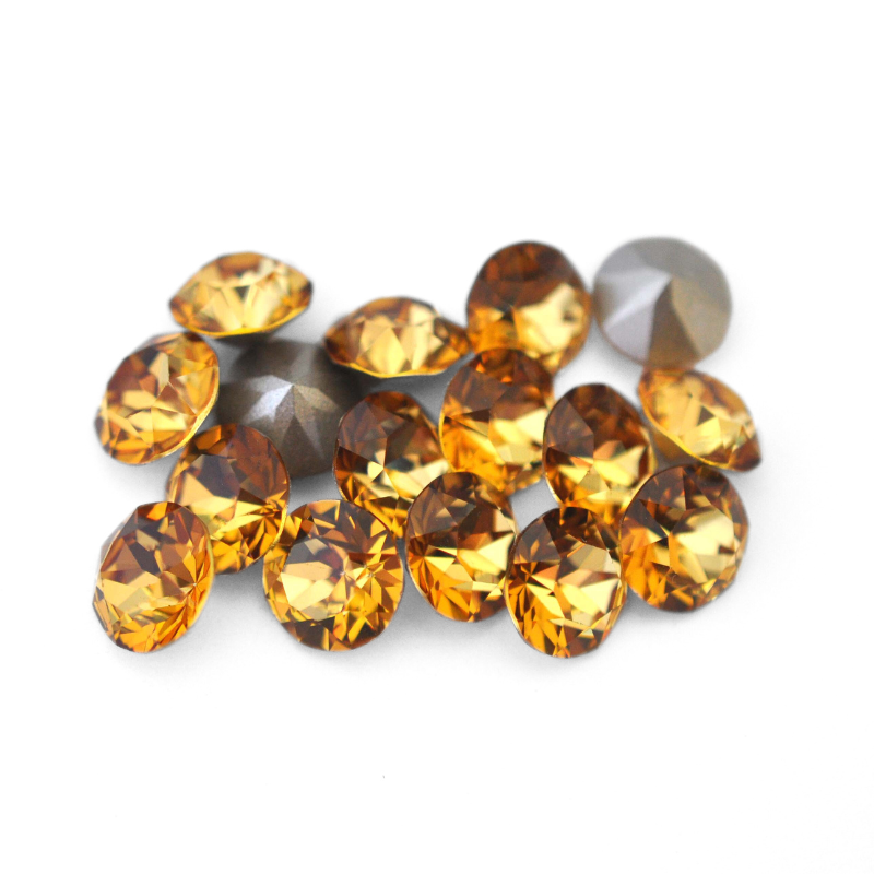 Round faceted Austrian crystal rhinestones in the color Golden Topaz displayed on a white background.