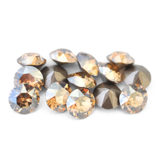 Round faceted Austrian crystal rhinestones in the color Golden Shadow displayed on a white background.