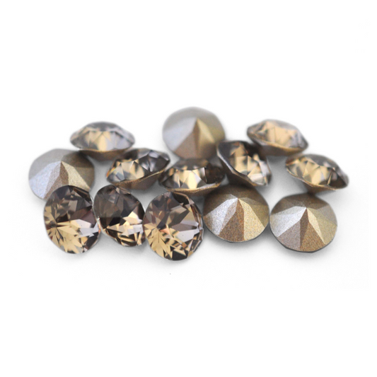 Round faceted Austrian crystal rhinestones in the color Greige displayed on a white background.