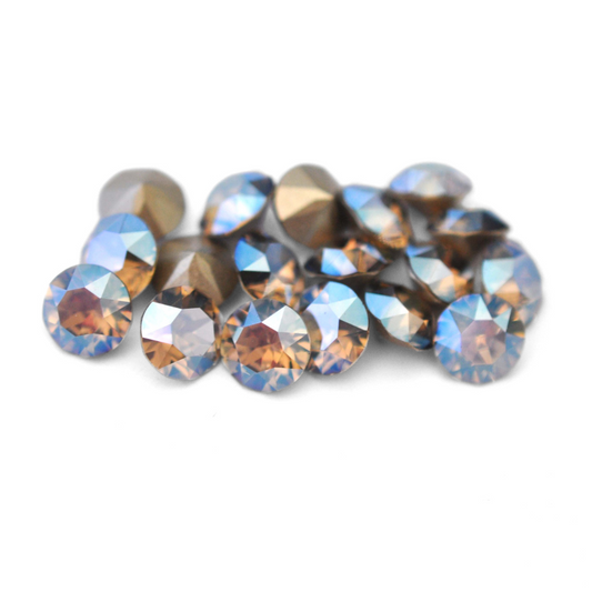 Round faceted Austrian crystal rhinestones in the color Greige Moonlight displayed on a white background