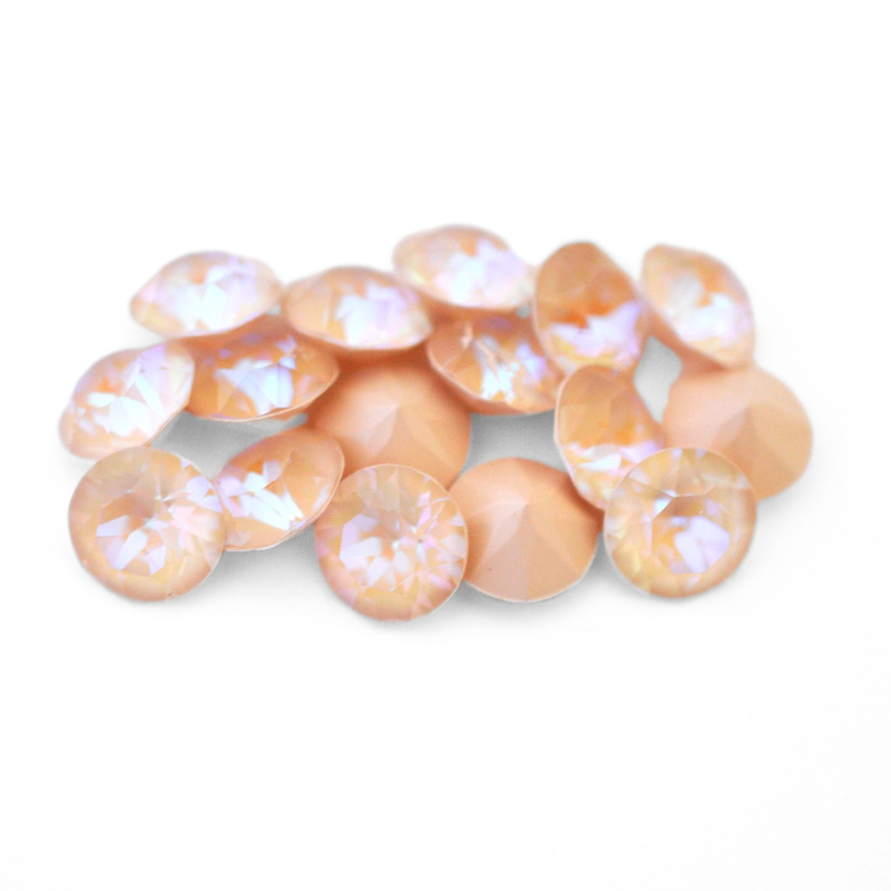 Round faceted Austrian crystal rhinestones in the color Ivory Cream Delite displayed on a white background.