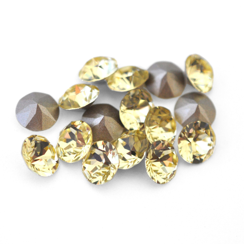 Round faceted Austrian crystal rhinestones in the color Jonquil displayed on a white background.