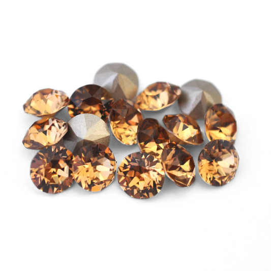 Round faceted Austrian crystal rhinestones in the color Light Colorado Topaz displayed on a white background.
