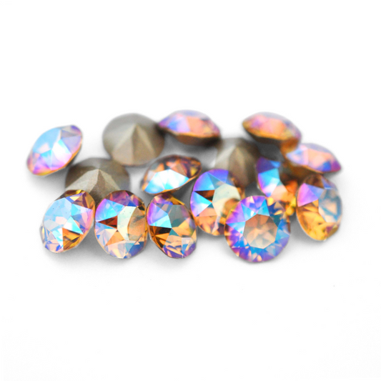 Round faceted Austrian crystal rhinestones in the color Light Colorado Topaz Shimmer displayed on a white background