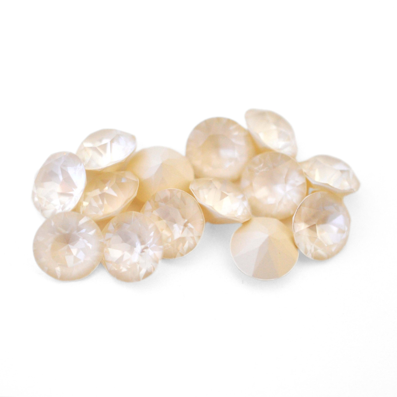 Round faceted Austrian crystal rhinestones in the color Linen Ignite displayed on a white background.