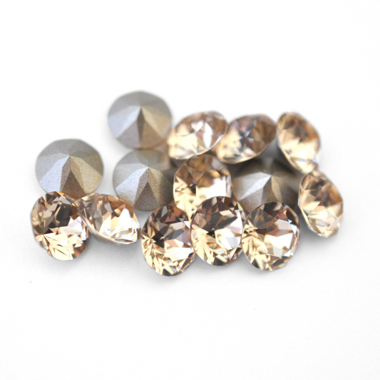 Round faceted Austrian crystal rhinestones in the color Light Silk displayed on a white background.