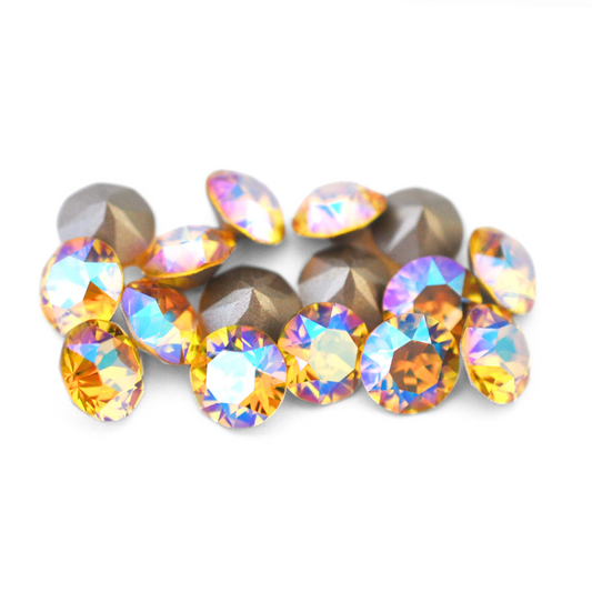 Round faceted Austrian crystal rhinestones in the color Light Topaz Shimmer displayed on a white background.