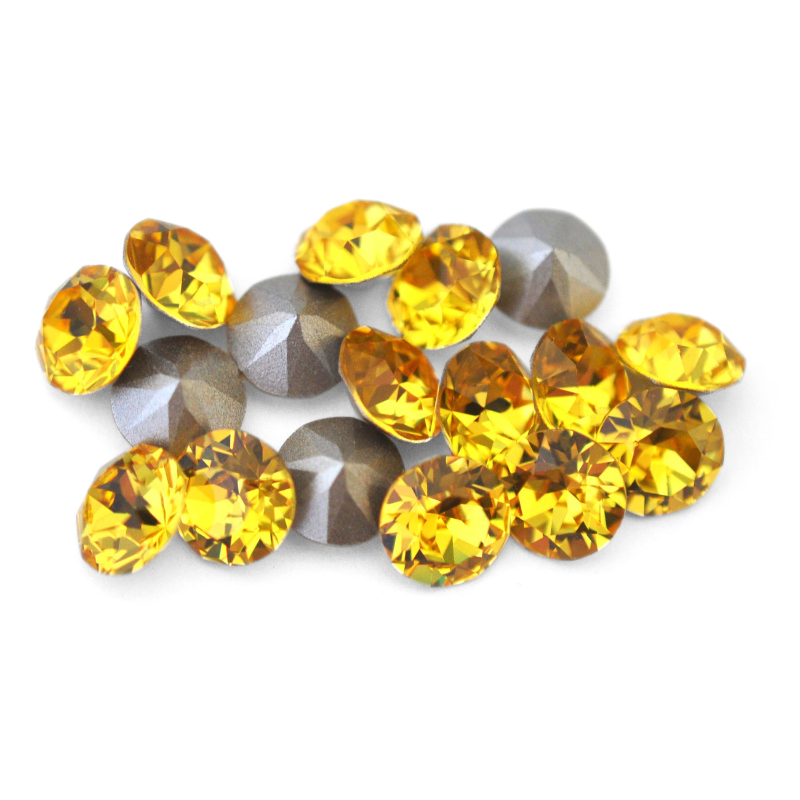 Round faceted Austrian crystal rhinestones in the color Light Topaz displayed on a white background.