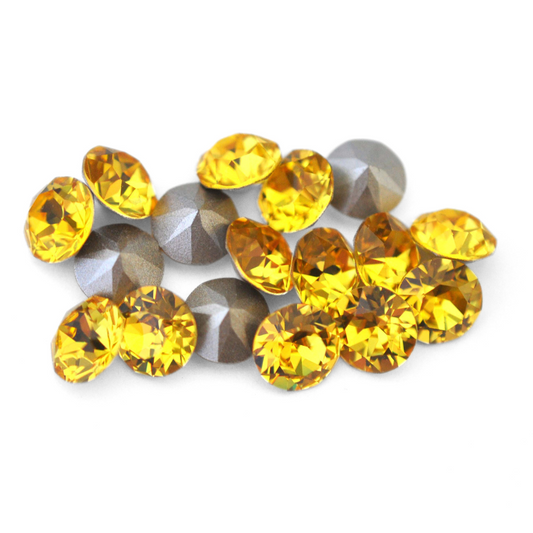 Round faceted Austrian crystal rhinestones in the color Light Topaz displayed on a white background.